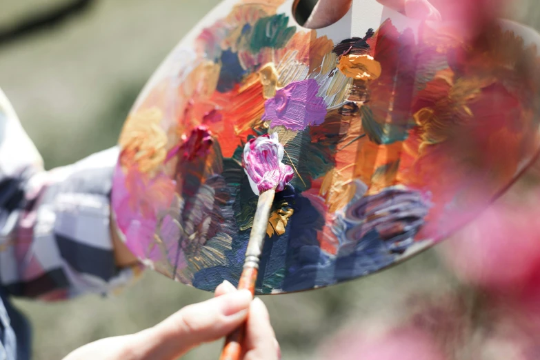 someone holding an artistically painted umbrella in front of a house