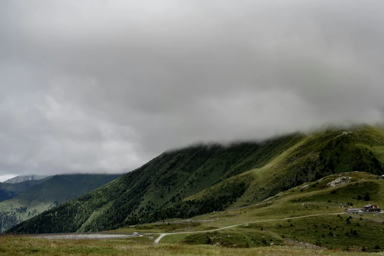 two sheep on a hill with a road going up