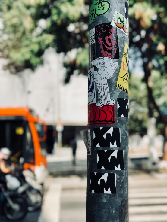 a pole has stickers all over it and street signs