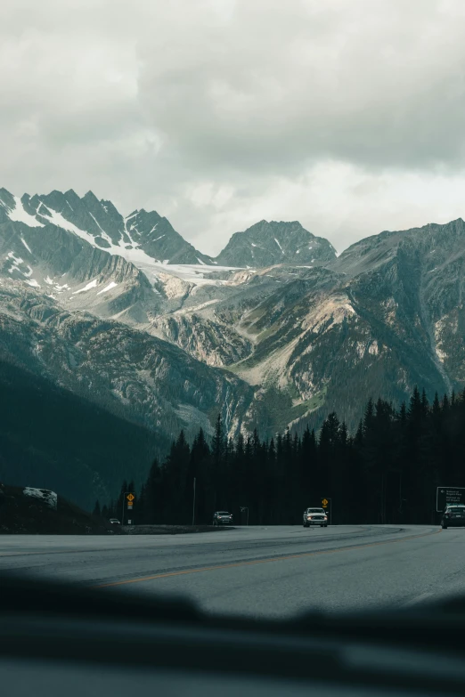 a car driving down a highway with mountains in the distance