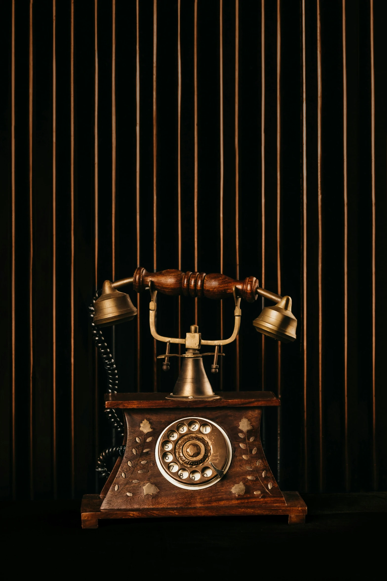 an antique phone is on the ground and in front of a corrugated wall