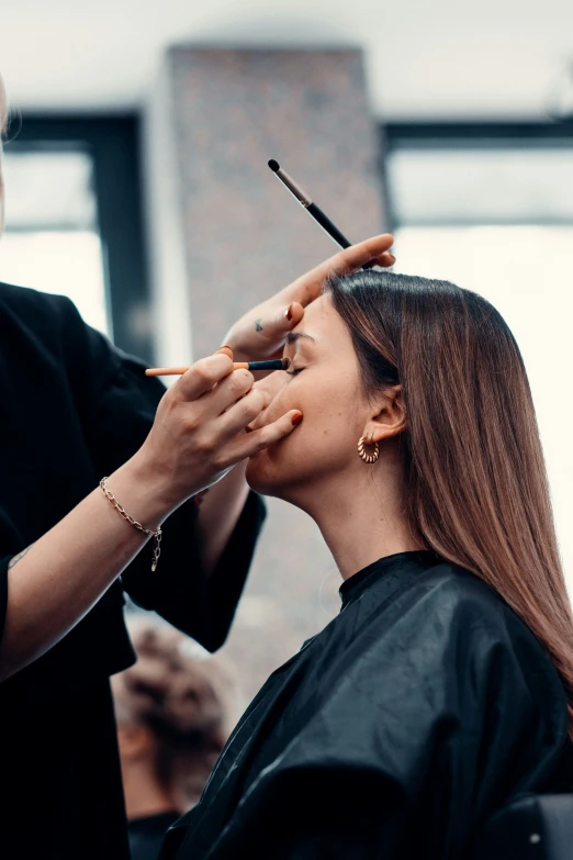 a woman gets her hair styled and styled