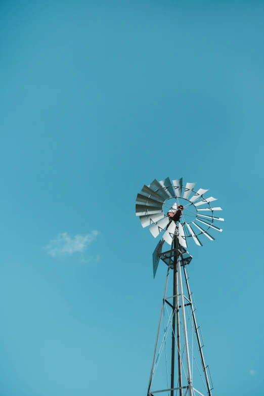 an old fashioned windmill on a clear blue sky