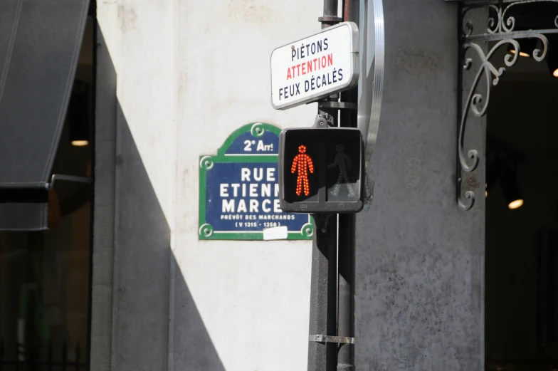 a street sign has a red figure with orange symbols