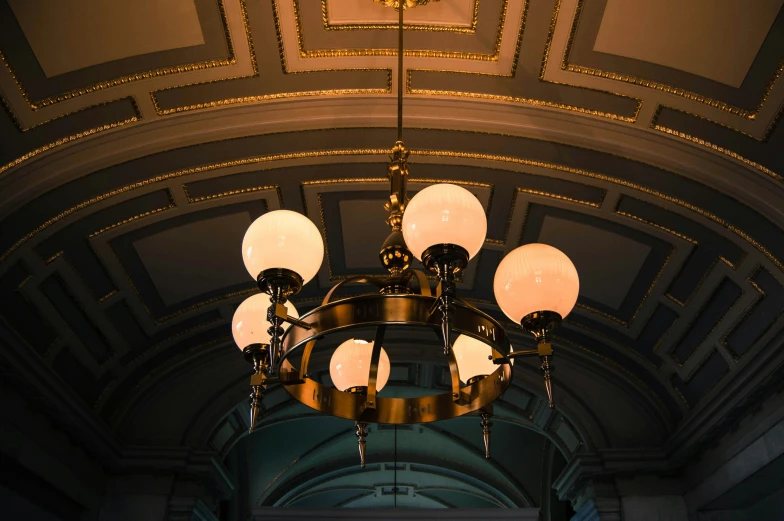 a fancy chandelier hangs in the center of a domed room