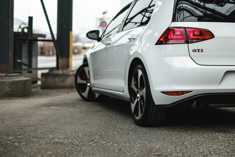 a white car is parked in front of an airport