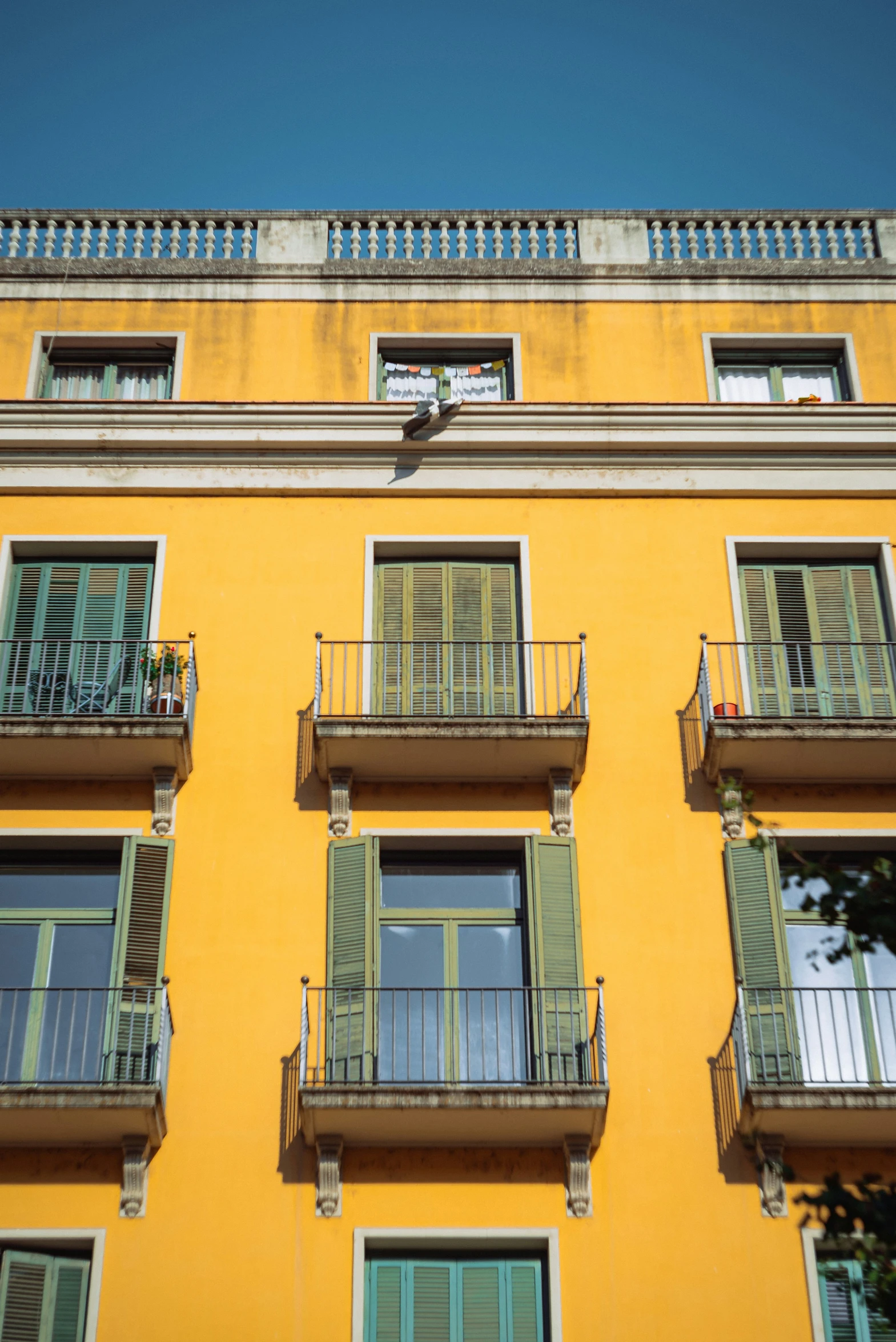 an outside view of a yellow building and some balconies