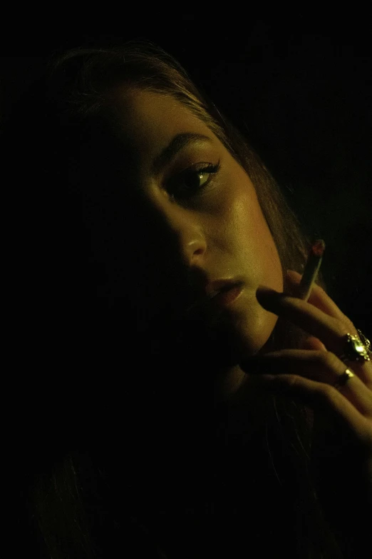 a woman smoking a cigarette in a dark room