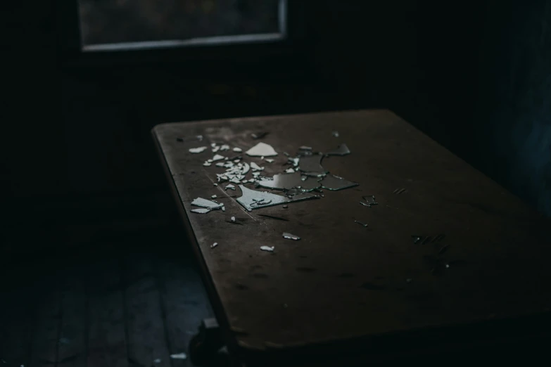 broken glass pieces on an old table in a dark room