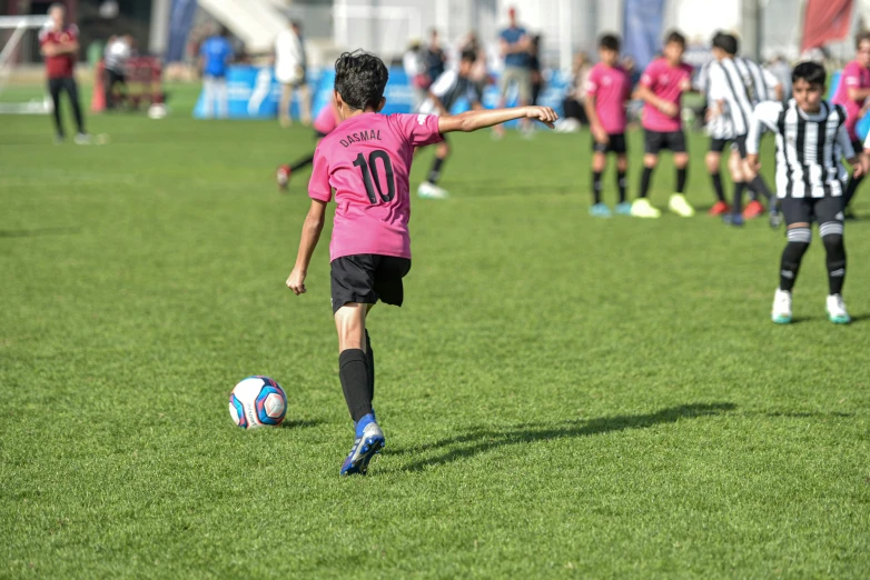 young children playing soccer on a green soccer field