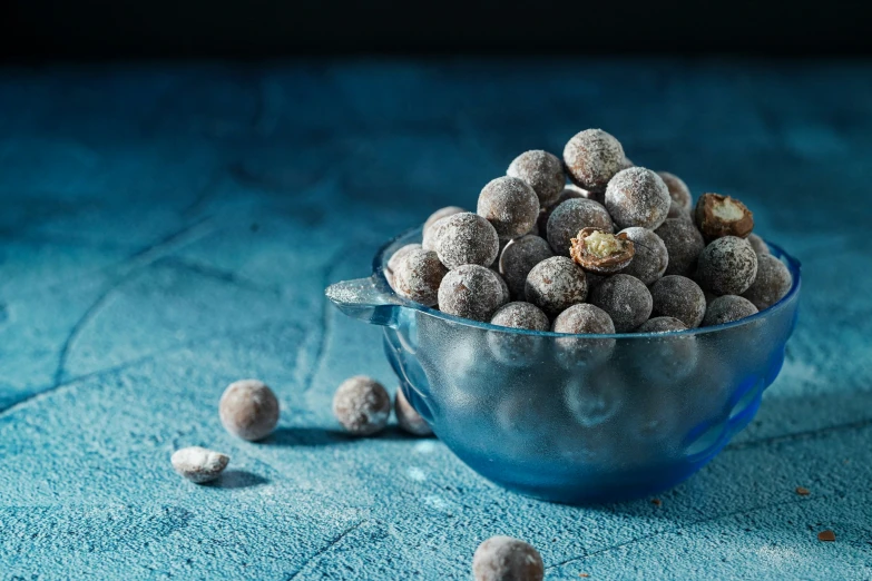 a blue bowl full of snowballs on a blue surface