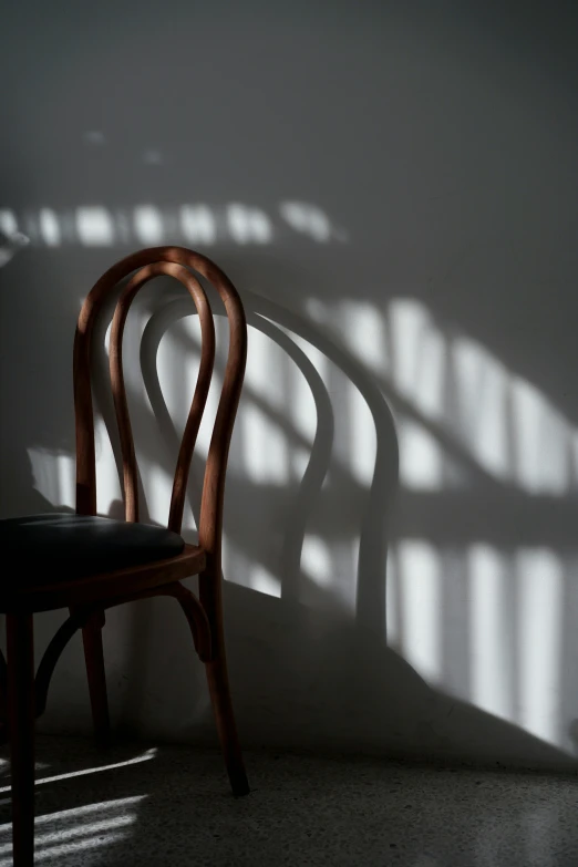 a chair casts a long shadow on the wall