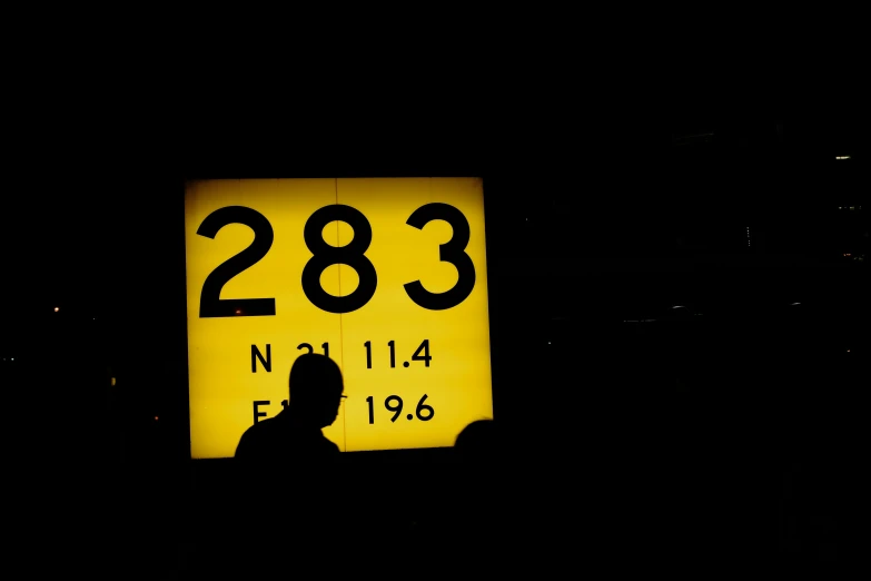 a person stands in front of a sign with numbers on it