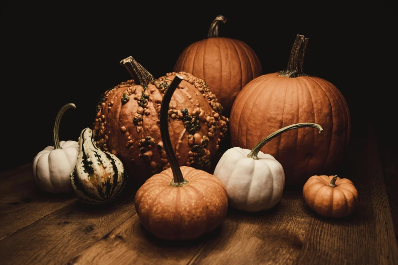 pumpkins are arranged on a table with white and green pumpkins