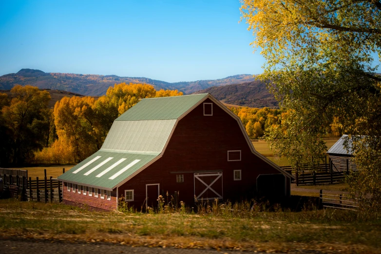 the barn with the roof is standing in the mountains