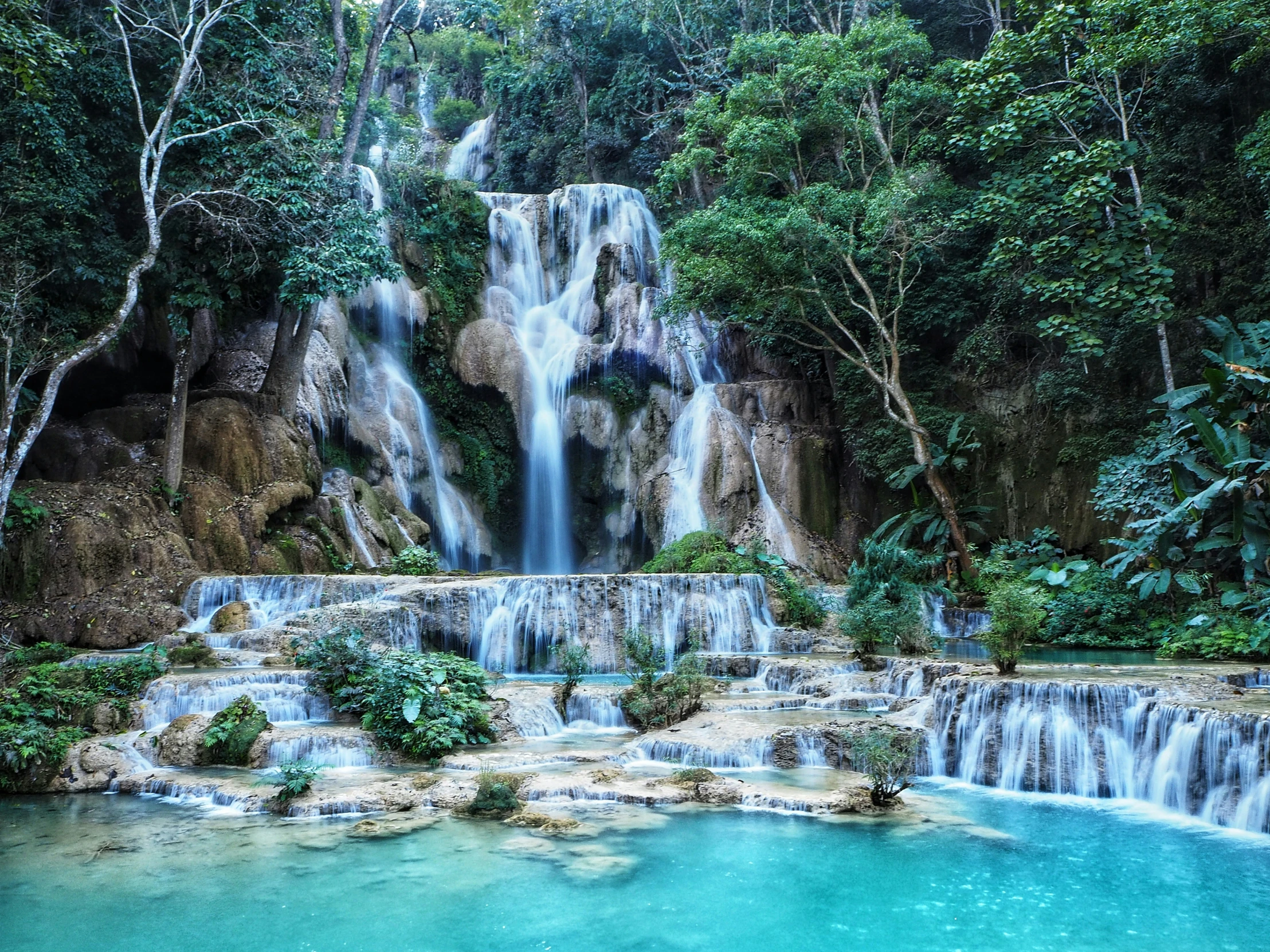 many waterfalls rise over the blue water