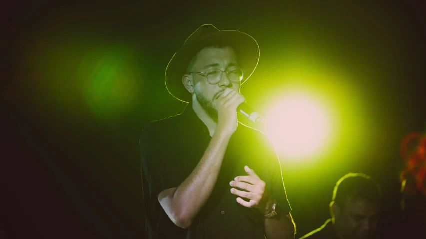 a man singing into a microphone on stage