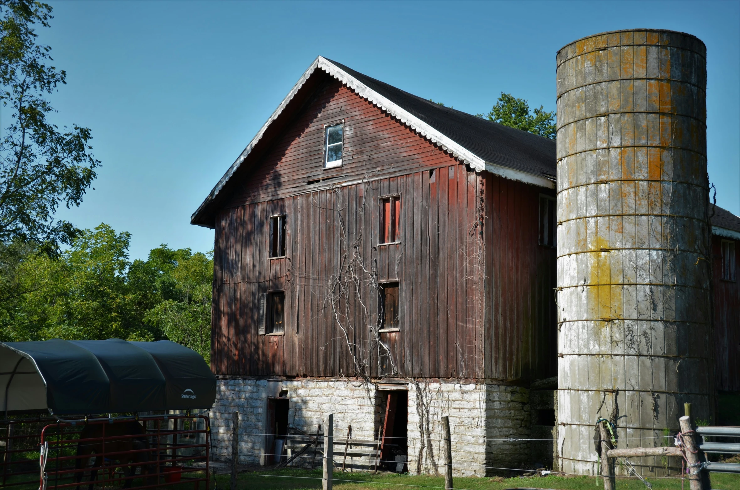 a barn and silo that is on the grass
