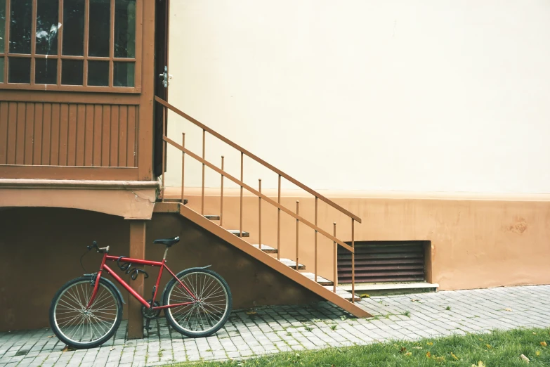 a bicycle resting against a staircase that is on the ground