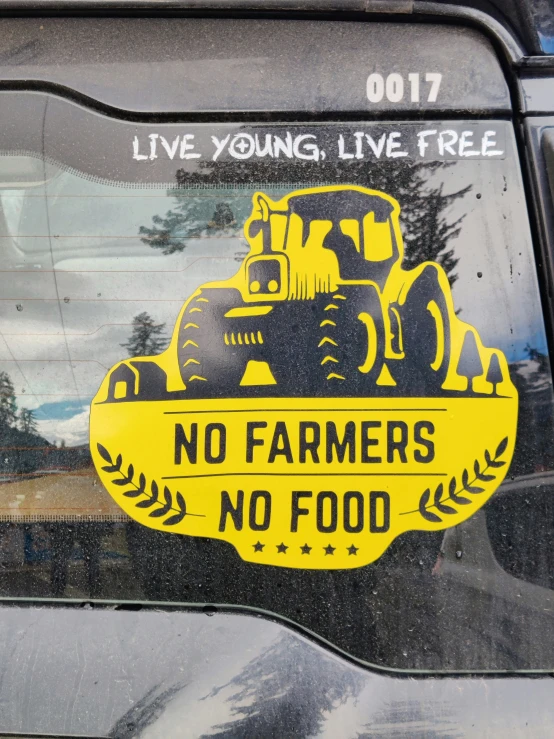 a yellow sign sitting on the side of a car that says, no farmers are food