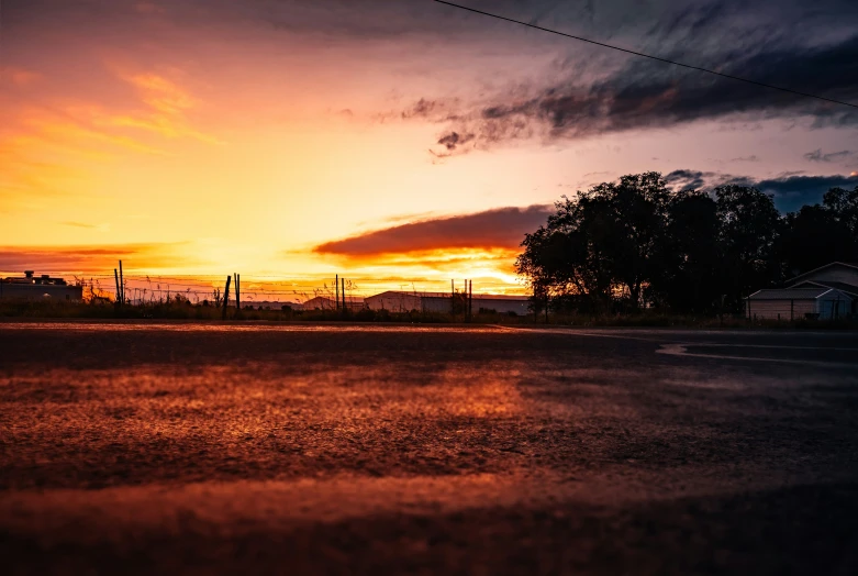 a street at dusk has an orange glow on the sky