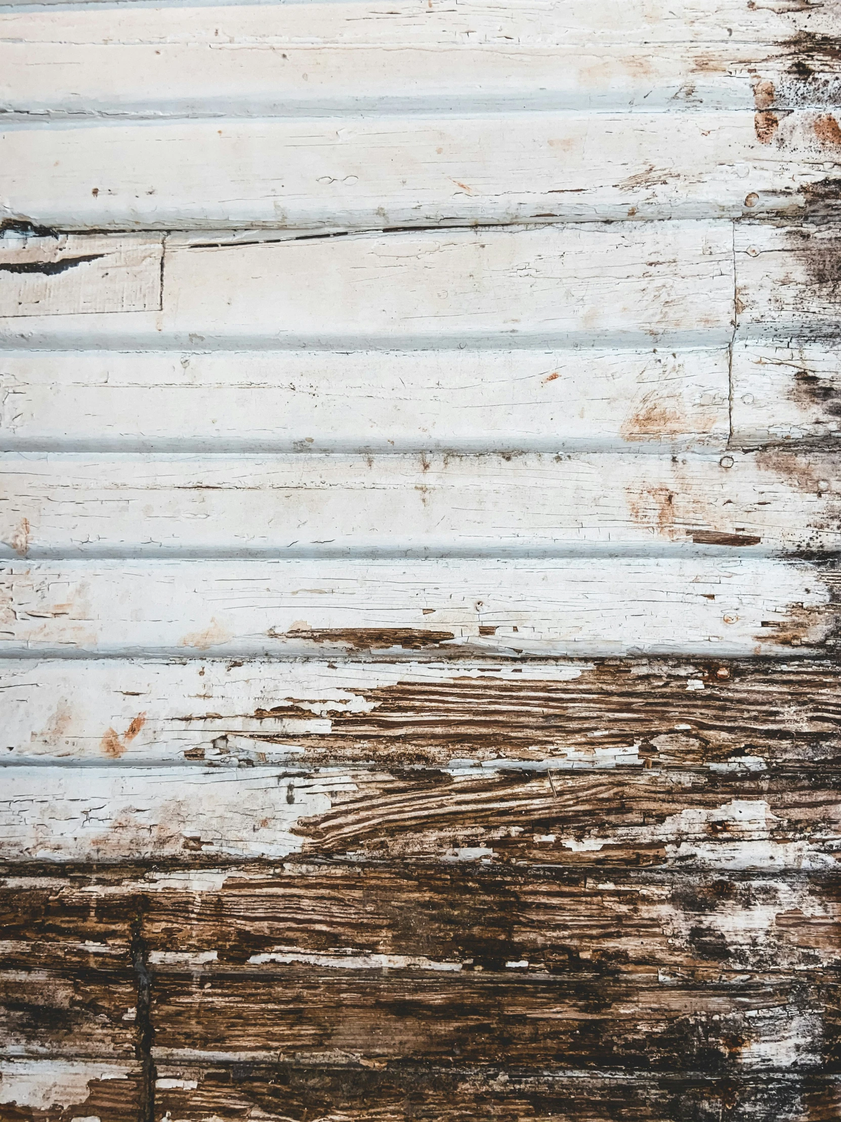 some rust and black paint on an old white board