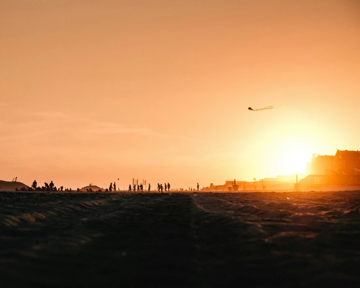 several people in a silhouette on an orange sky