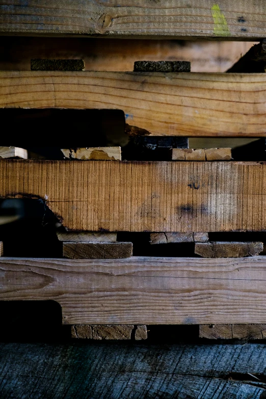 some wood is stacked high in the wooden pallets