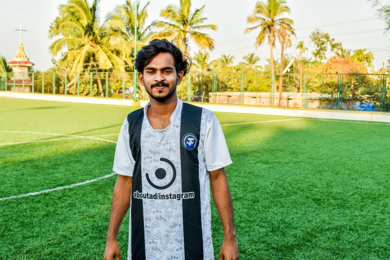 a soccer player standing on the field wearing a vest