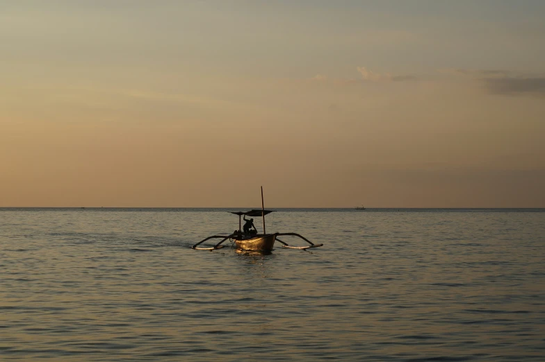 a boat out on the water at dusk