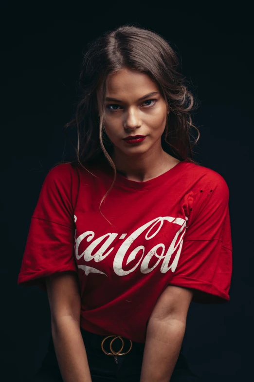 a beautiful young woman wearing a coca cola t - shirt