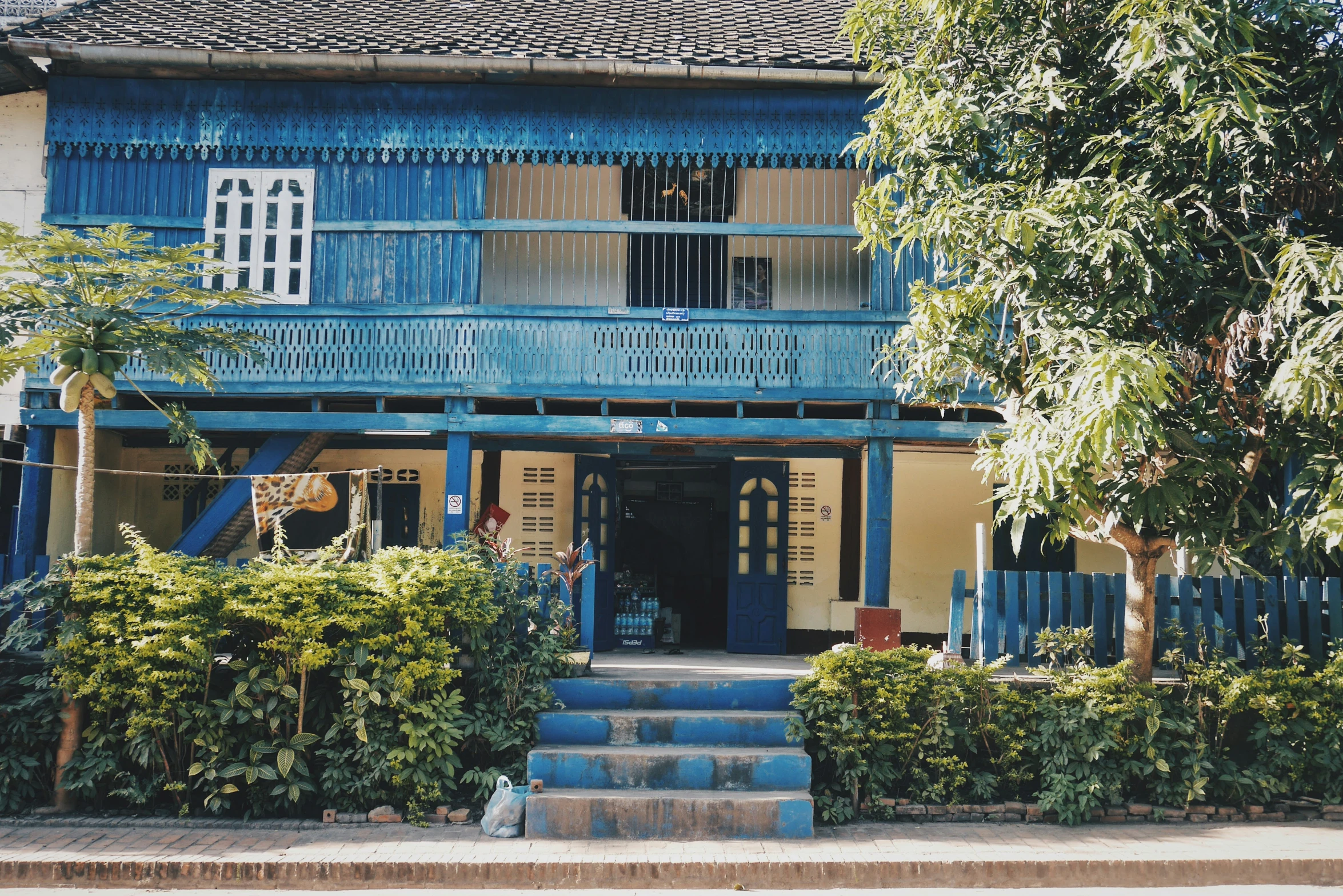an outside view of a small building with blue siding and stairs