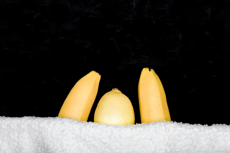 four fruit are sitting together on a towel