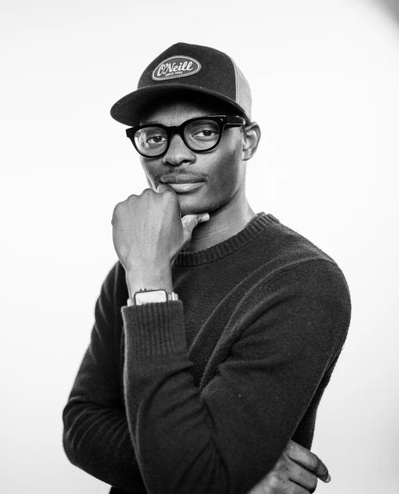 a black man wearing glasses, a hat and a sweater