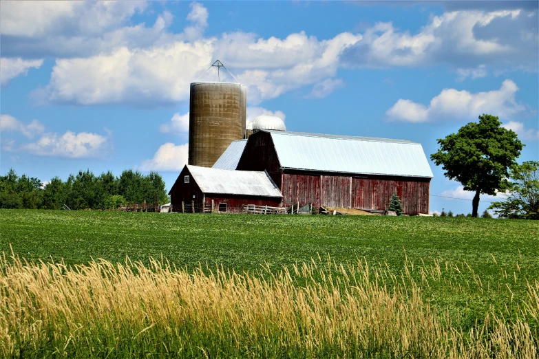 a farm scene with a barn and silos