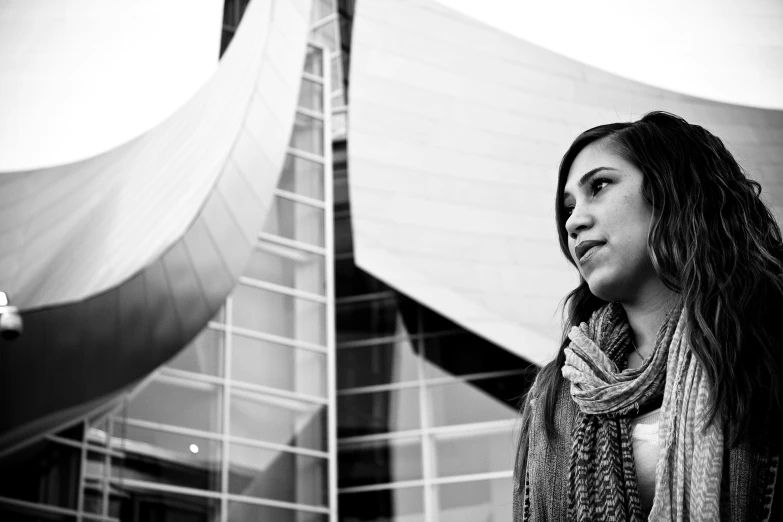 this woman is standing in front of a building and she is looking away from the camera