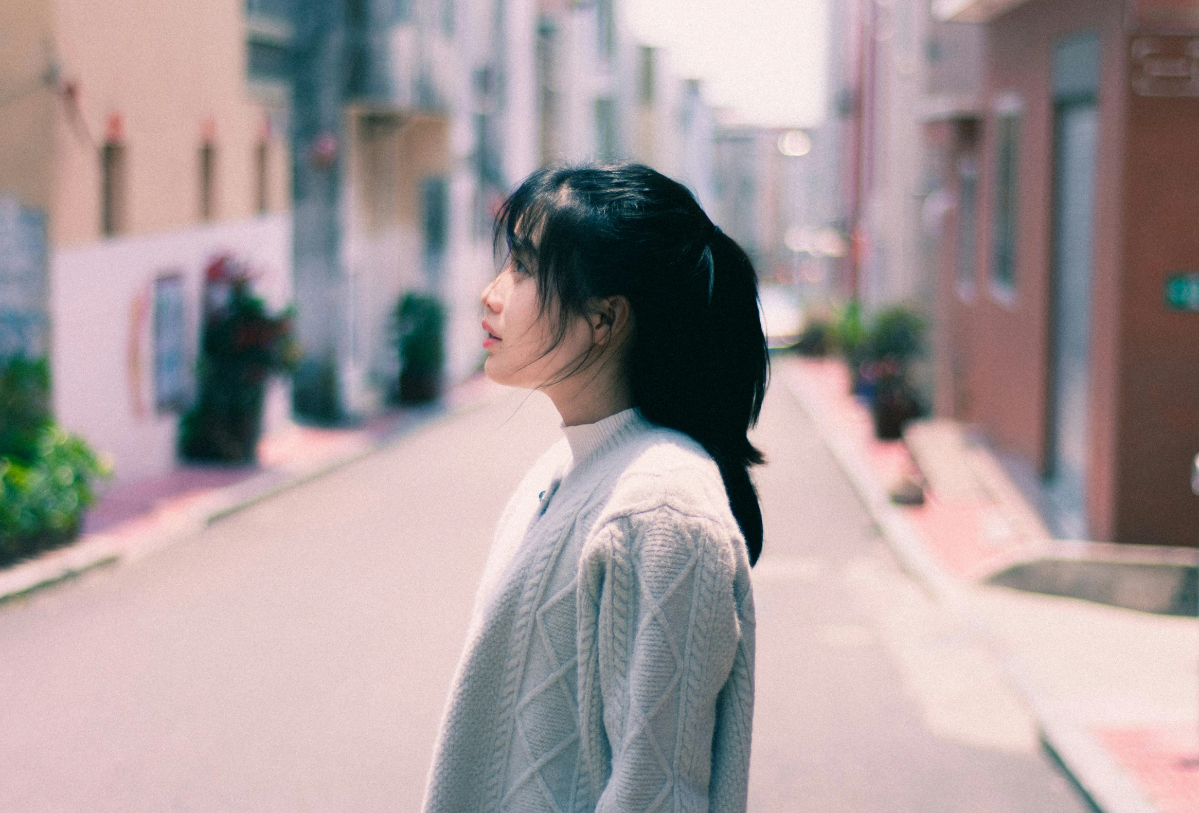 a young woman stands alone on the street