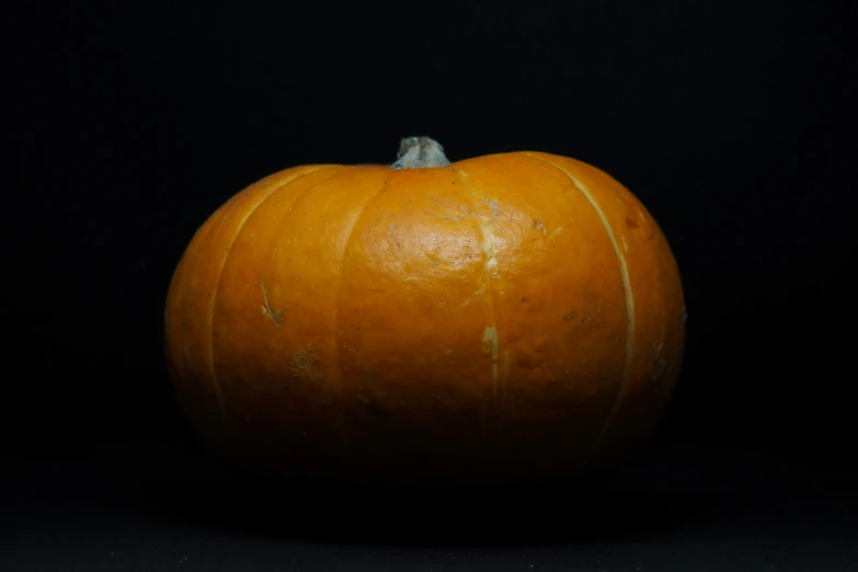 an orange sitting on top of a black background