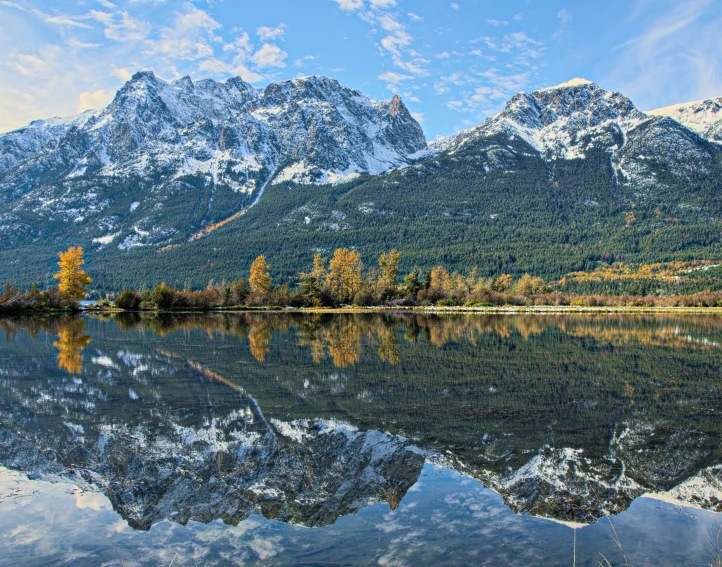 a large mountain covered in snow next to a body of water