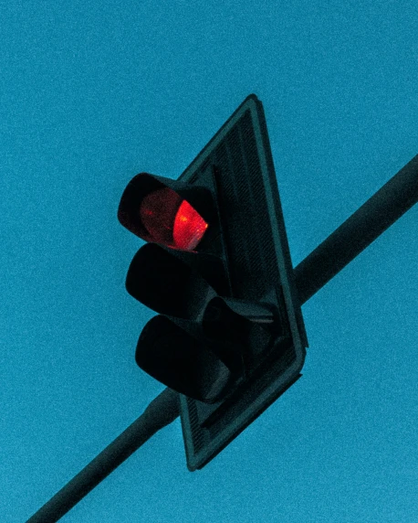a traffic signal that is red, on a pole