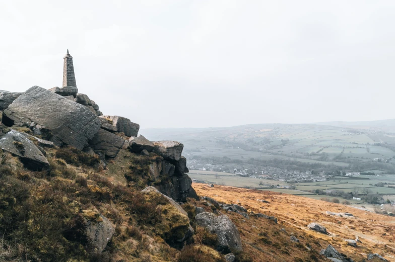 a man sitting on top of a rock structure on a hill