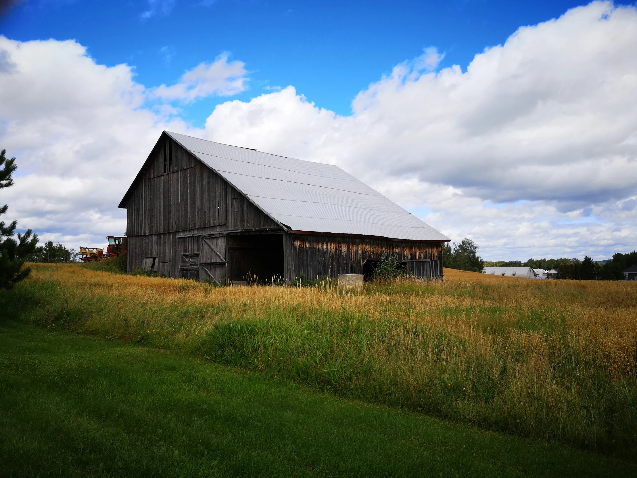 an old barn in the countryside under a blue sky