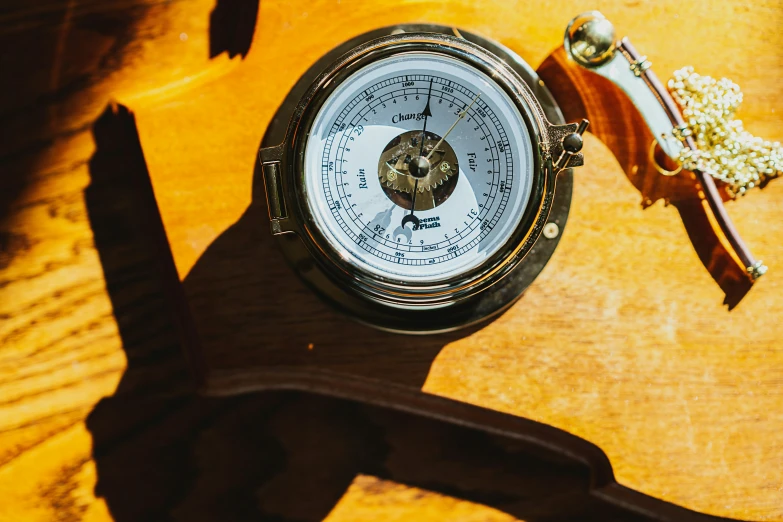 a barometer sitting on top of a table next to keys