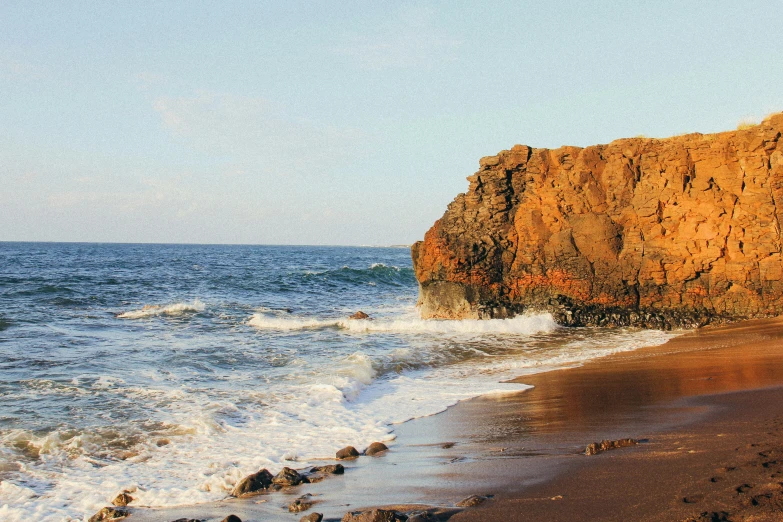 the water in front of a rocky cliff on the ocean