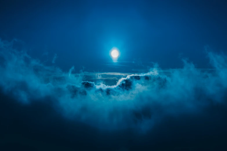 the bright moon is lit over the clouds