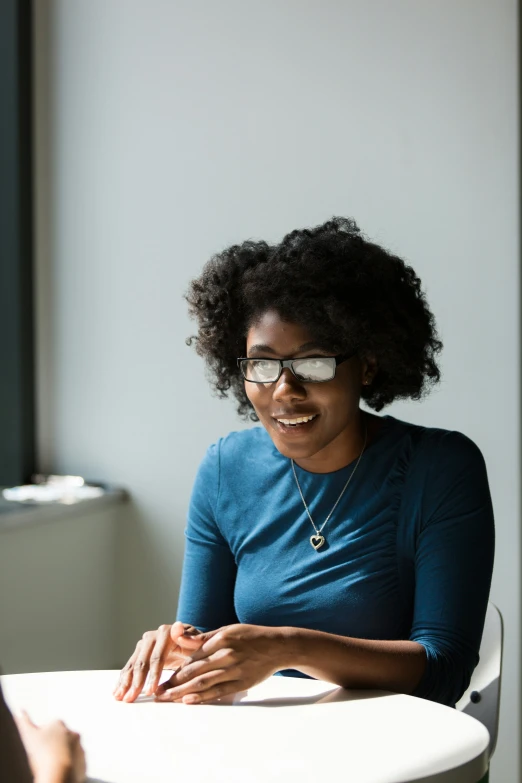 a person sitting at a table wearing glasses