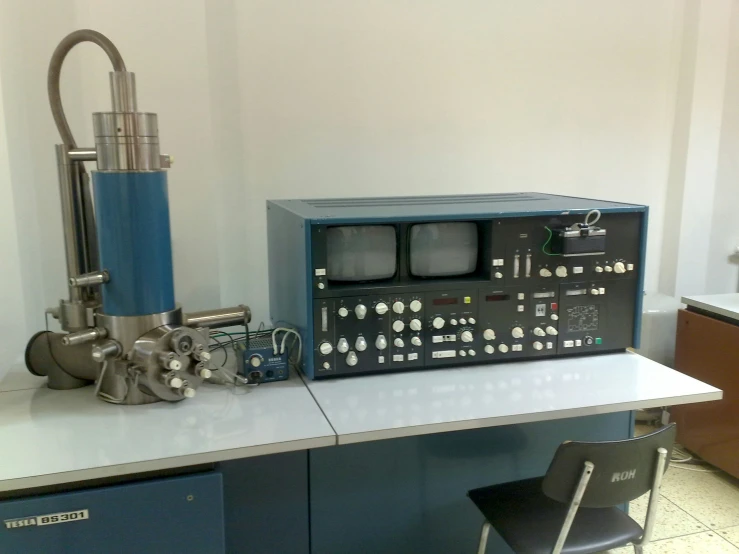 a machine on top of a desk next to some chairs