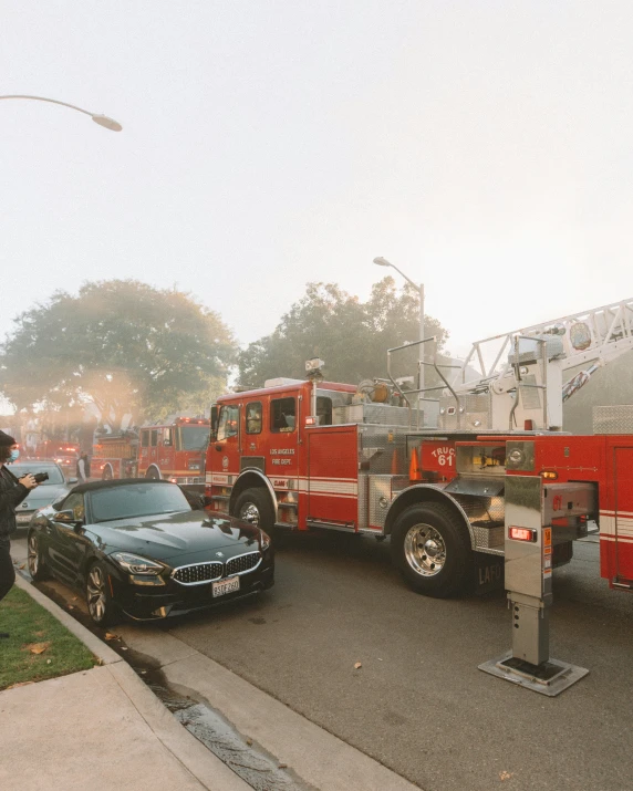 a black car parked next to a firetruck in a parking lot