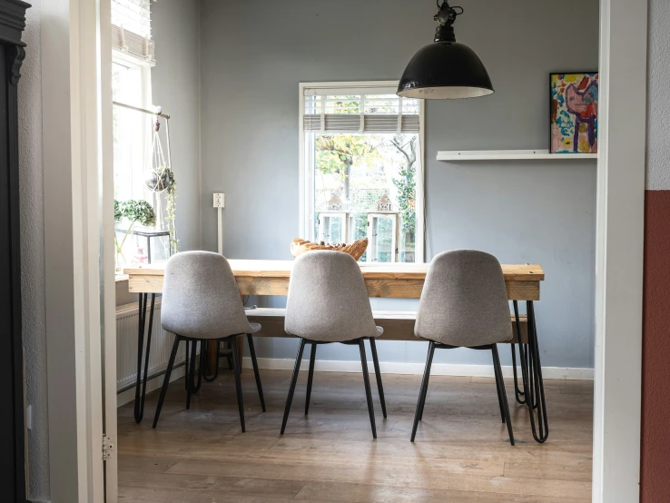 a very neat room with a wooden dining table in the middle of it