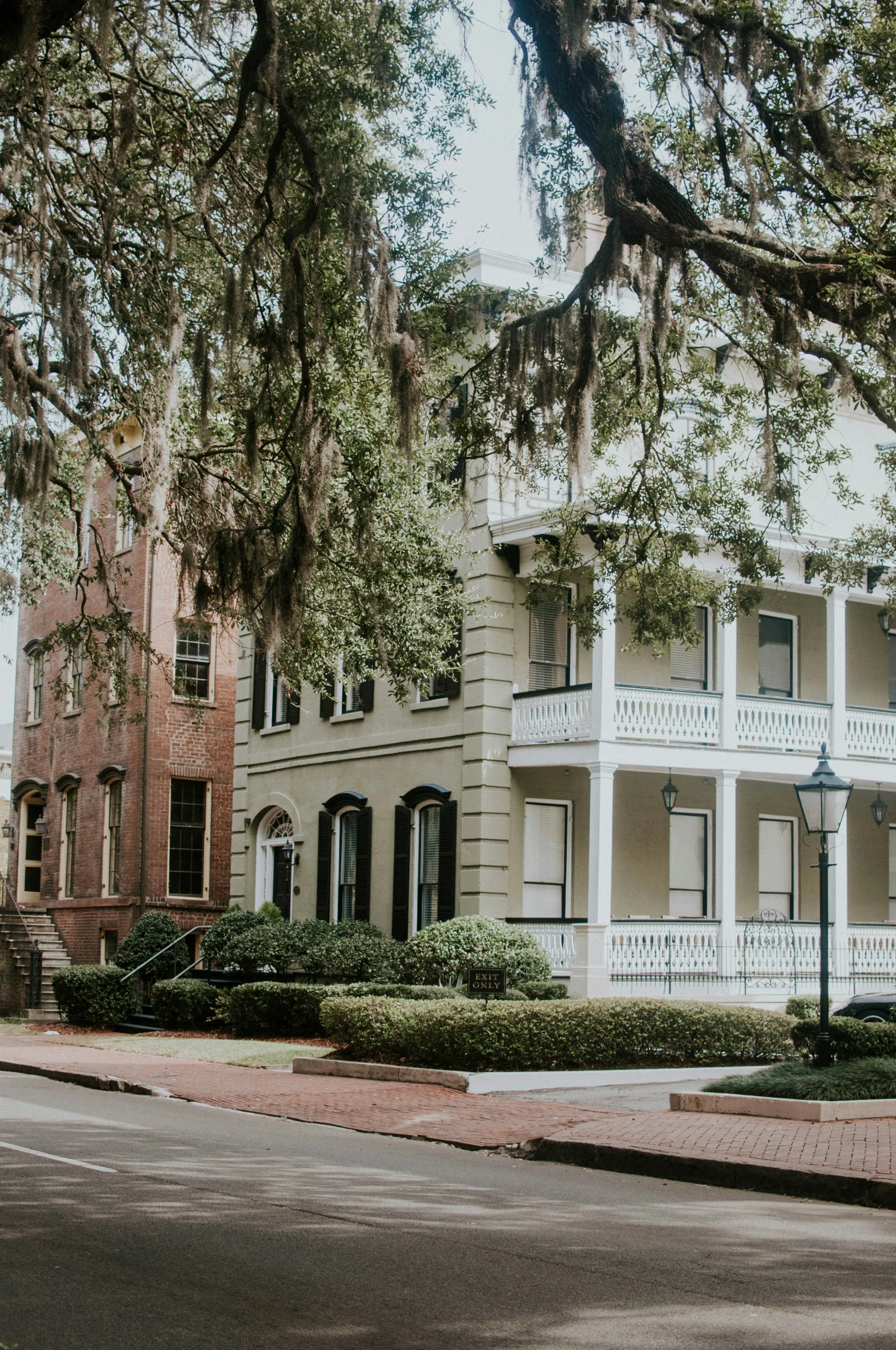 the large white house is sitting on the corner by a tree